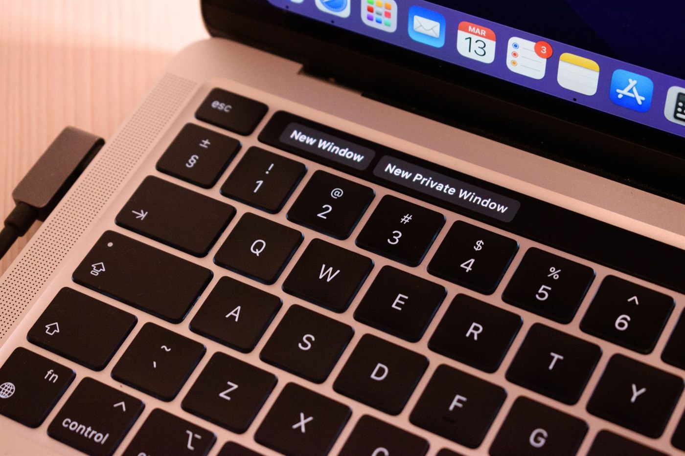 A laptop keyboard in close-up with a browser menu open on the screen above it